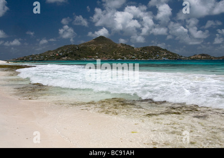 Petit St. Vincent Beach View mit türkisfarbenen Karibischen Meer, Wellen und Petit Martinique. PSV, St. Vincent und die Grenadinen. Stockfoto