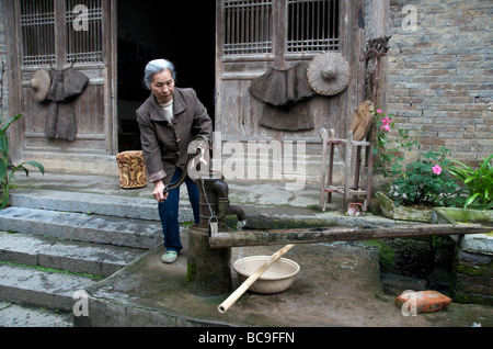 Frau Wasserholen in traditionellen alten Haus in der Nähe von Yangshuo Guangxi China Stockfoto