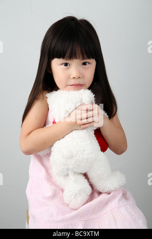 chinesische Mädchen umarmt einen Teddybär Stockfoto