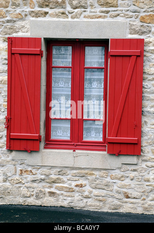 Leuchtend roten Fensterläden und nautischen Gardine auf Haus, Roscoff, Bretagne, Frankreich Stockfoto