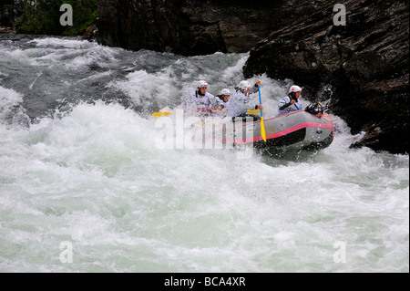 Ein Team von Wildwasser weibliche Sparren steuern Sie ihr Boot durch Stromschnellen Stockfoto