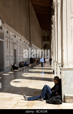 Touristen und Besucher ausruhen im Schatten unter Bögen an die großen Omayyaden-Moschee, Damaskus, Syrien Stockfoto