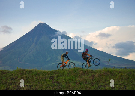 Professionelle Mountainbiker Hans Rey und Brian Lopes am Vulkan Mount Mayon, Philippinen Stockfoto