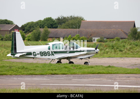 Grumman American AA-5 Traveller G-BBSA mit Crew verlassen Flugzeugs in Sandtoft Flugplatz geparkt. Stockfoto