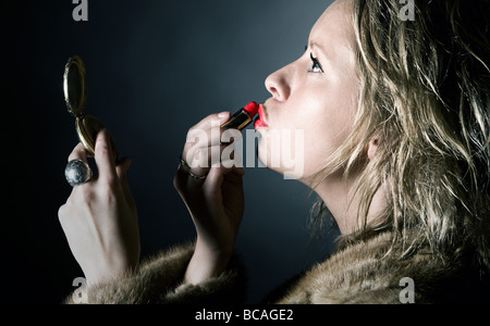 Schuss einen Vintage Stil weiblichen Anwendung ihren roten Lippenstift Stockfoto