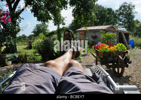 Stock Foto von einem mans Beine wie er sitzt in seinem Garten entspannen Stockfoto