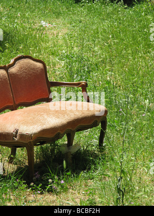eine alte beschädigte Sofa in Feld auf Land entsorgt Stockfoto