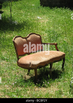 eine alte beschädigte Sofa in Feld auf Land entsorgt Stockfoto