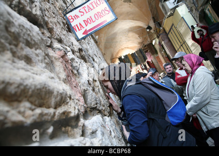 Christliche Pilger küsst die Mauer bei der achten Station des Kreuzweges an der Via Dolorosa in der Altstadt von Jerusalem. Stockfoto