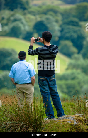 Ein Tourist in Wales mit dem Fotografieren von Llyn Gwynant auf einer digitalen Kompaktkamera. Stockfoto