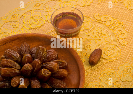 Arabischen Datumsangaben in einer hölzernen Platte mit Tasse Tee gerissen Stockfoto