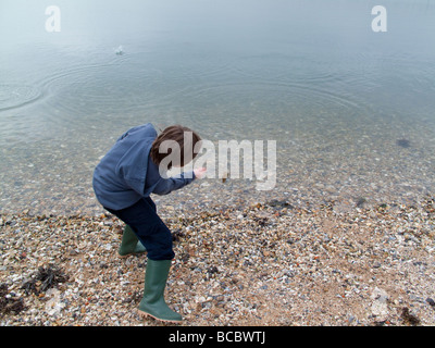 Little Boy skimming Stones in Lulworth Cove Stockfoto