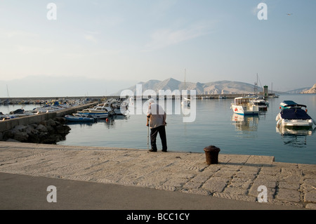 Ein älterer Mann läuft auf dem Hafendock Stockfoto