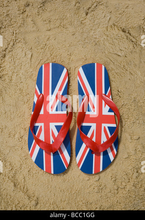 Union Jack Flip-flops am Sandstrand Stockfoto