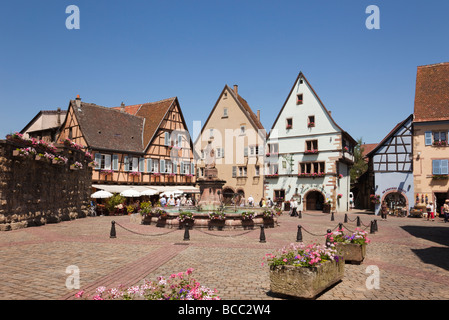 Straßenszene in Place du Chateau Platz im malerischen, mittelalterlichen Dorf auf der Weinstraße. Eguisheim Oberrhein Elsass Frankreich. Stockfoto