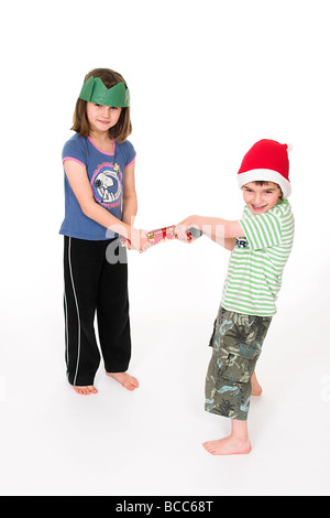 Junge Kinder ziehen ein Christmas Cracker Stockfoto