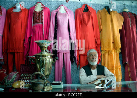 Ein Ladenbesitzer in Kabul der Chicken Street, Afghanistan, mit bunten Frauen Kleidung in der Öffentlichkeit noch nie gesehen Stockfoto