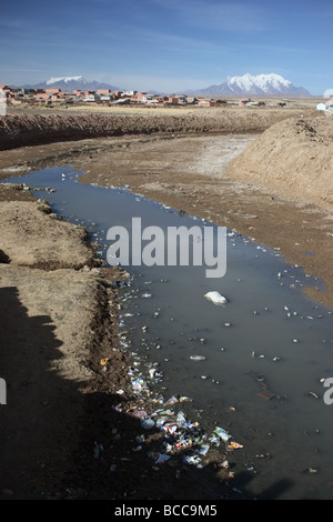 In stream Müll, Mts Mururata (L) und Illimani (R) im Hintergrund, Viacha, in der Nähe von El Alto, La Paz Department, Bolivien Stockfoto