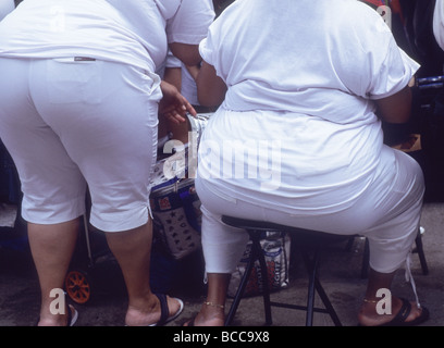 Rückansicht zweier fetter übergewichtiger Frauen in eng anliegender Hose. Einer sitzt und einer steht. Enge Kleidung an dicken Damen. USA Stockfoto