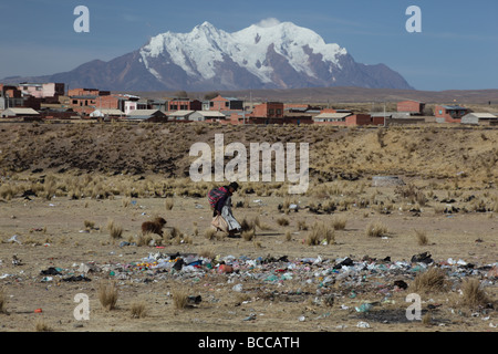 Indigenen Dame vorbei Abfall dump, Mt Illimani im Hintergrund, Viacha, in der Nähe von La Paz, Bolivien Stockfoto