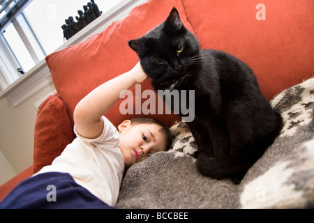 Kleiner Junge streicheln einer Katze zu Hause Island Stockfoto