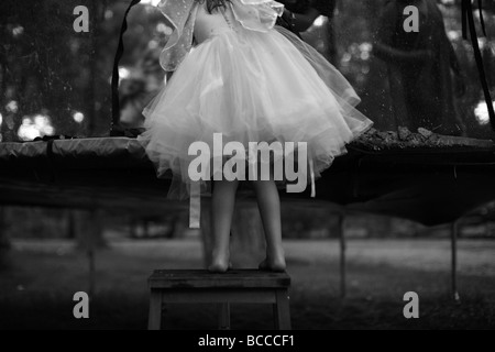Schwarz / weiß Bild der Mädchen im Märchen Kleid auf Hocker stehend Stockfoto