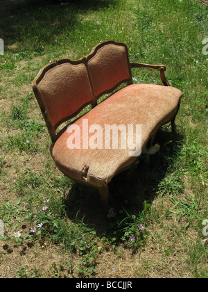 eine alte beschädigte Sofa in Feld auf Land entsorgt Stockfoto
