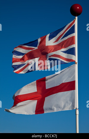 Union Jack und St George Flags im Wind fliegen in der Nähe von East Creech, Dorset, England Stockfoto