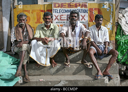 Vier indische Männer saßen In einer Stadt Markt, Munnar, Kerala, Indien Stockfoto