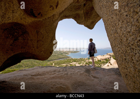 Touristen genießen Sie den Blick von unterhalb der Wind geformt Bear Rock am Capo d ' Orso in Richtung Palau und La Maddalena, Sardinien Stockfoto