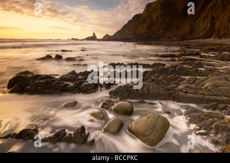 Stimmungsvolle Dämmerung Sonnenuntergang über schroffe Felsen am dramatischen Hartland Quay an der Küste von North Devon UK Stockfoto