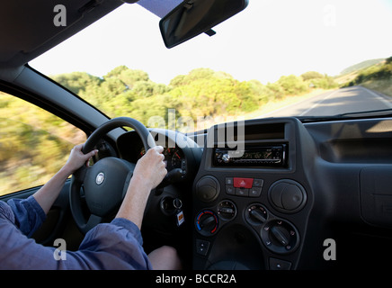 Eine anonyme Frau Autofahren, Straße gesehen durch Windschutzscheibe Stockfoto