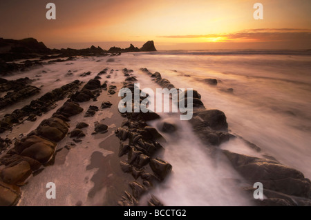 Stimmungsvolle Dämmerung Sonnenuntergang über schroffe Felsen am dramatischen Hartland Quay an der Küste von North Devon UK Stockfoto