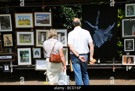 Besucher Studium Exponate einer Kunstausstellung in Cheltenham Festival Gloucestershire England UK Stockfoto