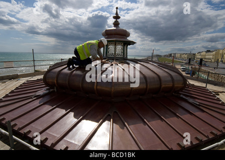 Ein Arbeiter hämmern ein neues Kupferdach auf einen viktorianischen Musikpavillon auf Brighton und Hove direkt am Meer Stockfoto