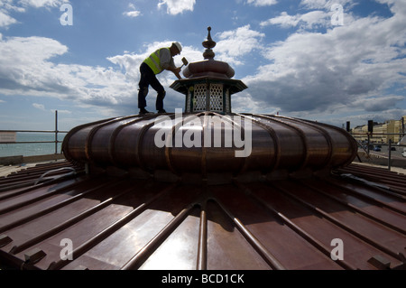 Ein Arbeiter hämmern ein neues Kupferdach auf einen viktorianischen Musikpavillon auf Brighton und Hove direkt am Meer Stockfoto