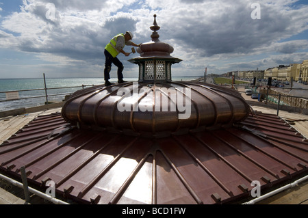 Ein Arbeiter hämmern ein neues Kupferdach auf einen viktorianischen Musikpavillon auf Brighton und Hove direkt am Meer Stockfoto