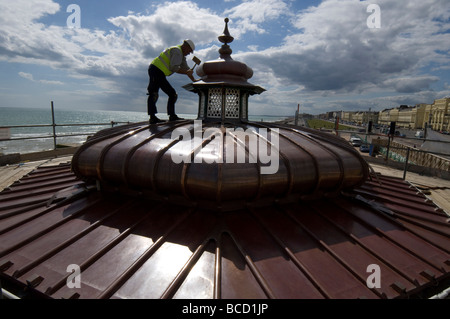 Ein Arbeiter hämmern ein neues Kupferdach auf einen viktorianischen Musikpavillon auf Brighton und Hove direkt am Meer Stockfoto