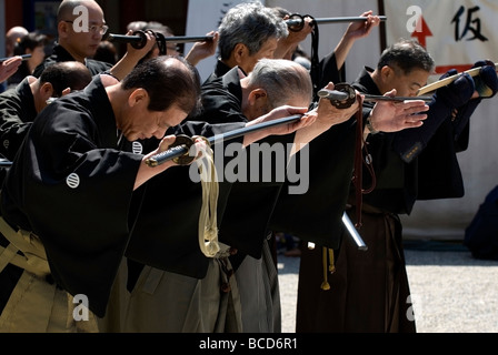 Gruppe von Männern mit echter Samurai Schwerter in eine Geste des Respekts während einer Schwertkunst Martial-Arts-demonstration Stockfoto