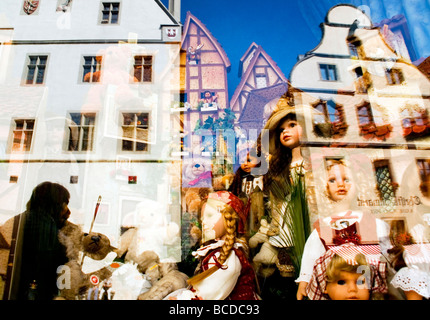 Rothenburg Ob der Tauber mittelalterliche alte Stadtarchitektur mit Straßenmusiker spiegelt sich im Fenster der Spielzeug-Shop mit Puppen Stockfoto