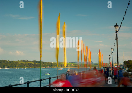 Massen von Menschen zu Fuß Vergangenheit farbigen hell Fahnen flattern im Wind am Strand von Appledore North Devon UK Stockfoto