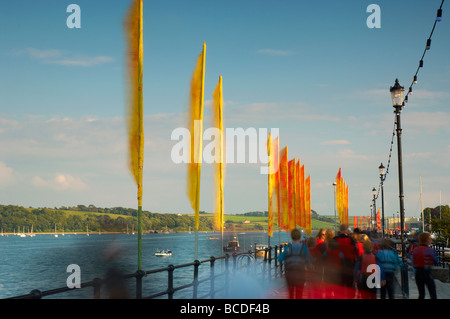 Massen von Menschen zu Fuß Vergangenheit farbigen hell Fahnen flattern im Wind am Strand von Appledore North Devon UK Stockfoto