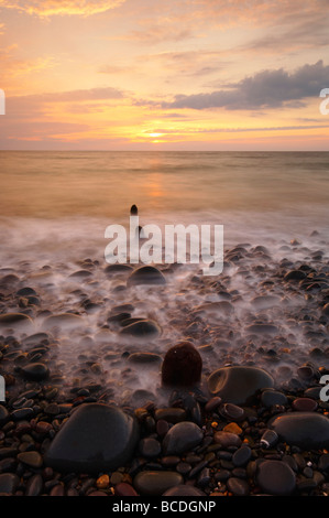 Stimmungsvollen Sonnenuntergang über den steinigen Strand von Westward Ho auf der Nord-Devon UK Stockfoto