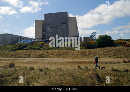 Mann zu Fuß Hund am Strand vor Sizewell A Nuclear Power Station, Leiston, Suffolk, UK Stockfoto