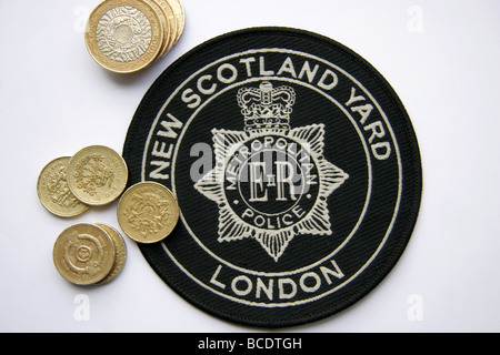 London Metropolitan Police New Scotland Yard-Patch und Pfund-Münzen Stockfoto