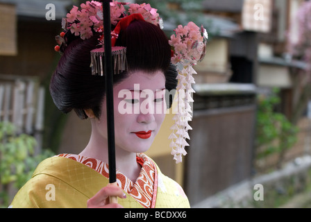 Ein weiblicher Touristen verkleidet als Maiko oder Lehrling Geisha mit Feder Kanzashi Dekorationen im Haar hat einen ruhigen moment Stockfoto