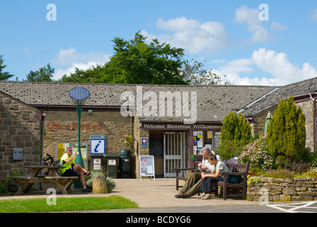 Drei Menschen entspannen außerhalb einmal gebraut Tourist Information Centre, Bardon Mill, Northumberland, England UK Stockfoto