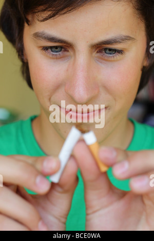 Jugendlicher bricht eine Zigarette Stockfoto