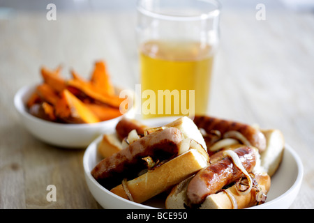 Frisch gekochte Wurst aus Schweinefleisch Hot Dogs mit Zwiebeln in einem weißen Brot Crusty Roll serviert in einer Schüssel mit Keine Personen Stockfoto