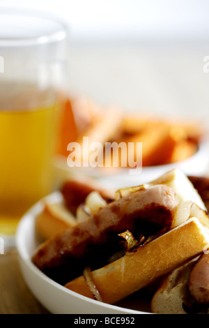 Frisch gekochte Wurst aus Schweinefleisch Hot Dogs mit Zwiebeln in einem weißen Brot Crusty Roll serviert in einer Schüssel mit Keine Personen Stockfoto